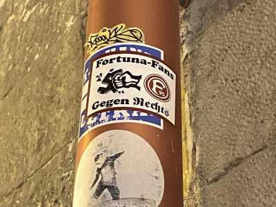Qualche metro pi� avanti scoviamo il simbolo del Fortuna Dusseldorf, team tedesco due volte campione nazionale. Sull�adesivo vediamo una svastica frantumata da un pugno, con sotto una frase traducibile come �contro la destra�